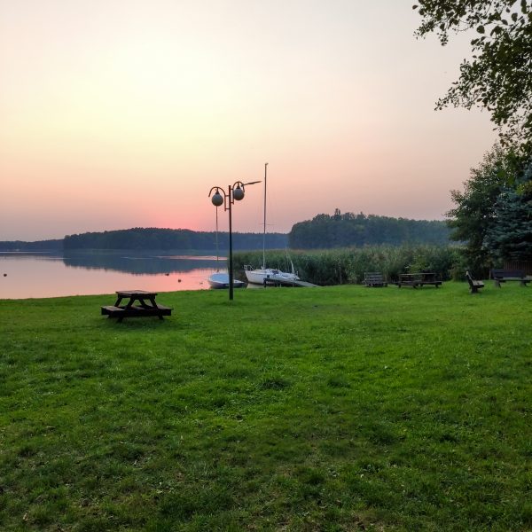 Trawa i łodzie nad jeziorem Rusałka Rudno noclegi jeziorem